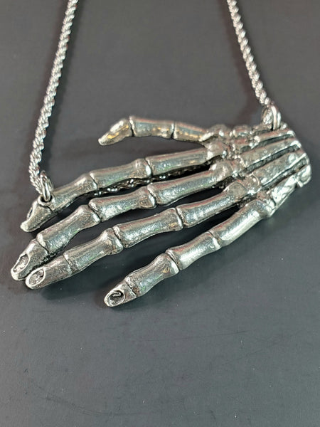 Large American pewter charm of a skeleton hand attached to a stainless steel rope chain 