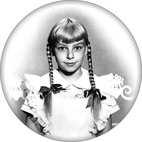 Round magnet with black and white image of Patty McCormack as Rhoda Penmark from the movie “The Bad Seed”