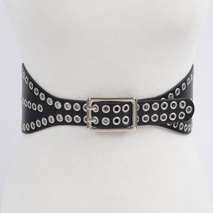 A 3 3/4’” wide matte black faux leather waist belt with two rows of silver metal eyelets and matching double pronged buckle. The belt has a shape that flares out at the hips. Shown on s dress form from the front