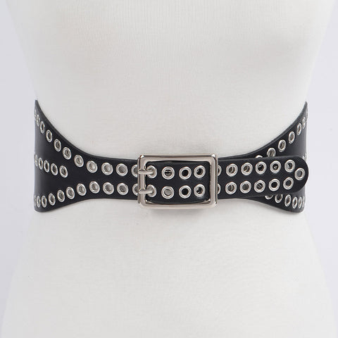 A 3 3/4’” wide matte black faux leather waist belt with two rows of silver metal eyelets and matching double pronged buckle. The belt has a shape that flares out at the hips. Shown on s dress form from the front