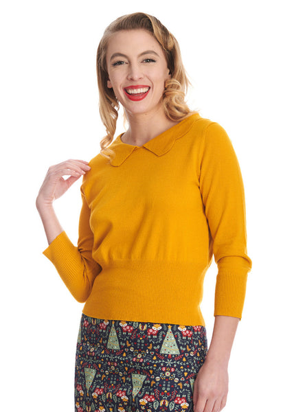 3/4 sleeve mustard yellow pullover sweater features a slightly bloused silhouette with nipped in ribbed waistband, and a scallop edge collar. Shown on a model.