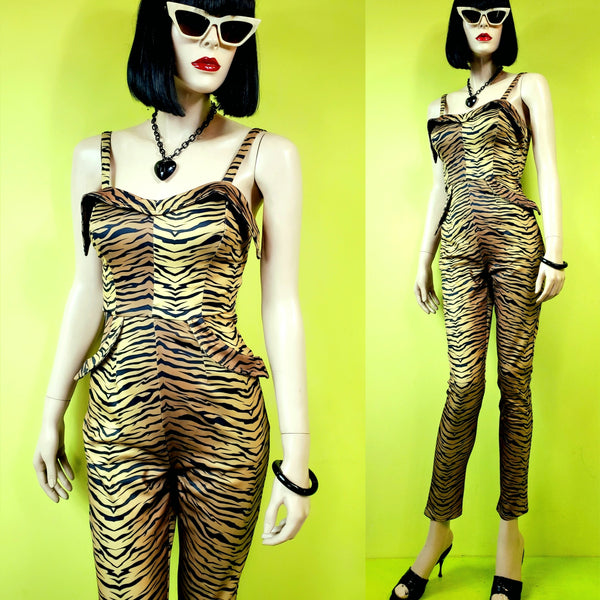 A mannequin wearing a tiger print catsuit made of a stretchy satin knit with adjustable straps and exaggerated cuff details at the sweetheart neckline and hip pockets