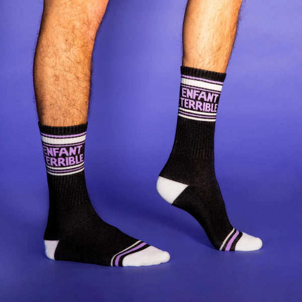 "Enfant Terrible” text on light purple, black, and gray ribbed knit stretch cotton blend crew length gym socks, shown on a model 