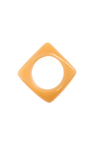 Shiny resin square bangle in a shade of beigey butterscotch brown with warped angular detail at each corner