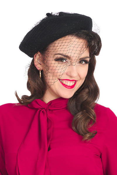 Black beret with black netting detail shown on a model 