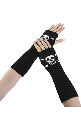 Black acrylic knit arm warmers with a white skull and crossbones design on the back of each hand. Shown worn by a model 