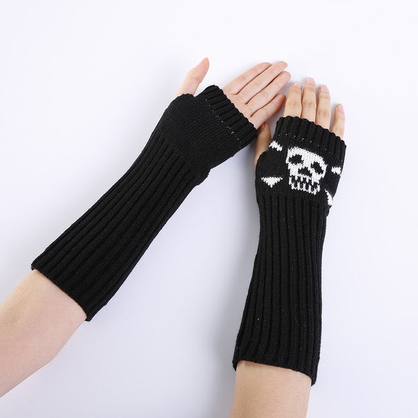 Black acrylic knit arm warmers with a white skull and crossbones design on the back of each hand. Shown worn by a model with one palm shown