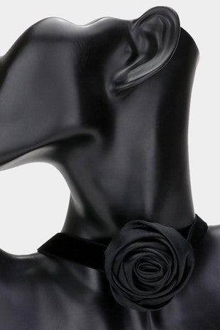 Black velvet choker with off-center silky black flower decoration seen on a mannequin 