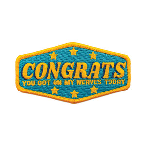 Bright yellow and blue twill embroidered patch “Congrats You Got On My Nerves Today” surrounded by small golden yellow stars 