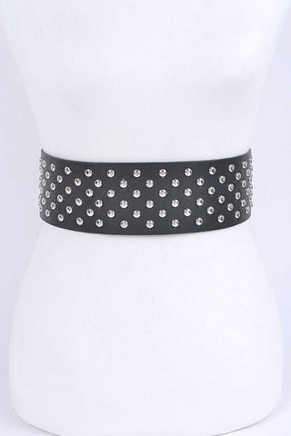 A black faux leather waist belt covered with silver metal round studs. Shown from front