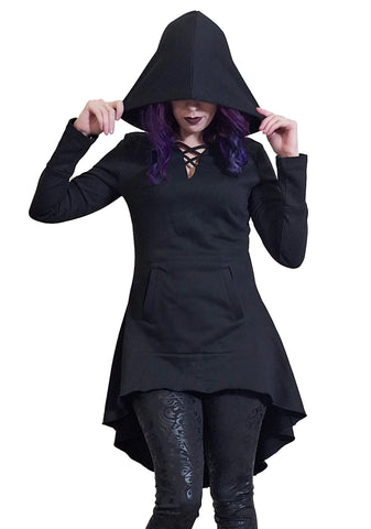 Model wearing black French Terry hoodie with feature neckline, long sleeves with thumb holes, a kangaroo pocket, oversized black hood (shown up), and a flared high-low hemline. Shown in close up