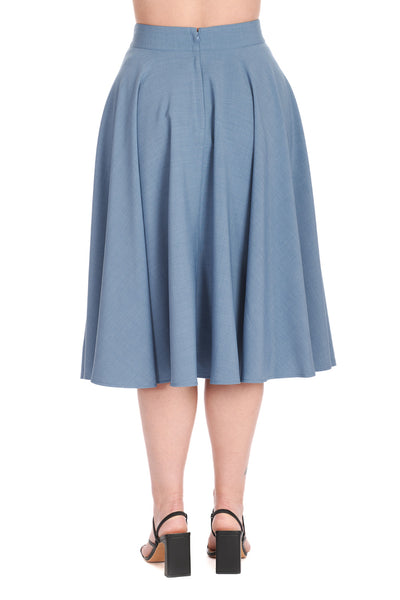 Model wearing a high-waisted swing skirt in a medium shade of cornflower blue that ends just below the knee. Shown from the back 