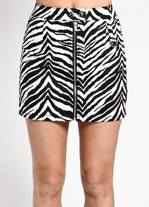 Zebra print cotton stretch mini skirt with double snap waistband and zipper down the front with d-ring detail at the left hip. Shown from the front