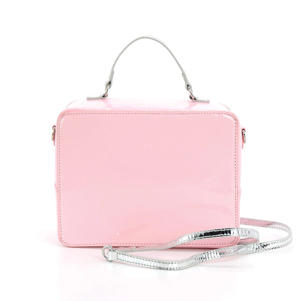 A rectangular novelty purse in the shape of a vintage television set in shiny pastel pink vinyl with silver details. Has a “screen” with a colorful test pattern and faux knob controls. Has a silver handle and detachable matching cross body strap. Shown from the back