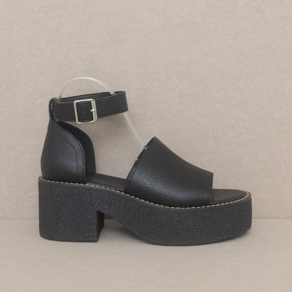 Black faux leather open toe platform sandals with matching ankle strap and silver metal buckle. Outsole is solid black textured rubber. Shown unworn from side