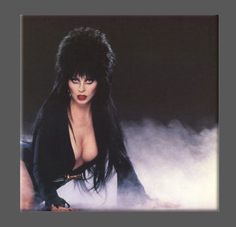 Square magnet with color portrait of Elvira reclining on a black background surrounded by fog