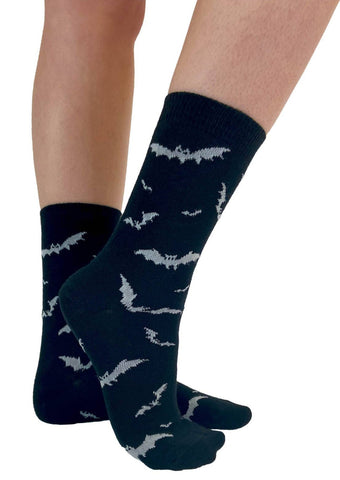 Black cotton blend crew socks with a white knit-in pattern of scattered flying bats. Shown worn by a model
