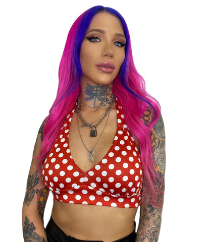 A model wearing a red halter top with white polka dots and a deep v-neck. Shown from the front