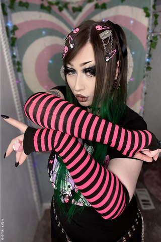 Model wearing black and pink striped arm warmers 