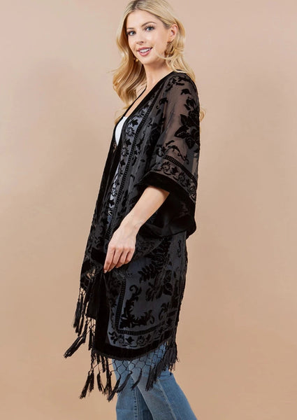 black burnout velvet rose patterned sheer cover-up/robe with an open front and black fringe detail at the hem, shown side view on a model