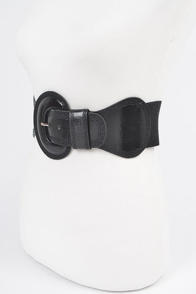 Shiny black faux leather elastic waist belt with self angled buckle. Shown from three quarter angle