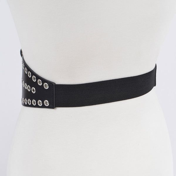 A 3 3/4’” wide matte black faux leather waist belt with two rows of silver metal eyelets and matching double pronged buckle. The belt has a shape that flares out at the hips. Shown from the side to display black elastic panel at back of belt