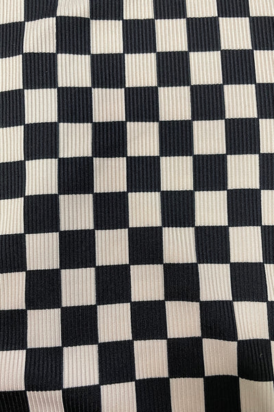 Ribbed knit fabric in black and creamy white checkerboard pattern shown in close up