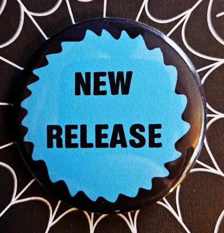 1.25” round button with “NEW RELEASE” written in black on a neon blue starburst shape on black background 