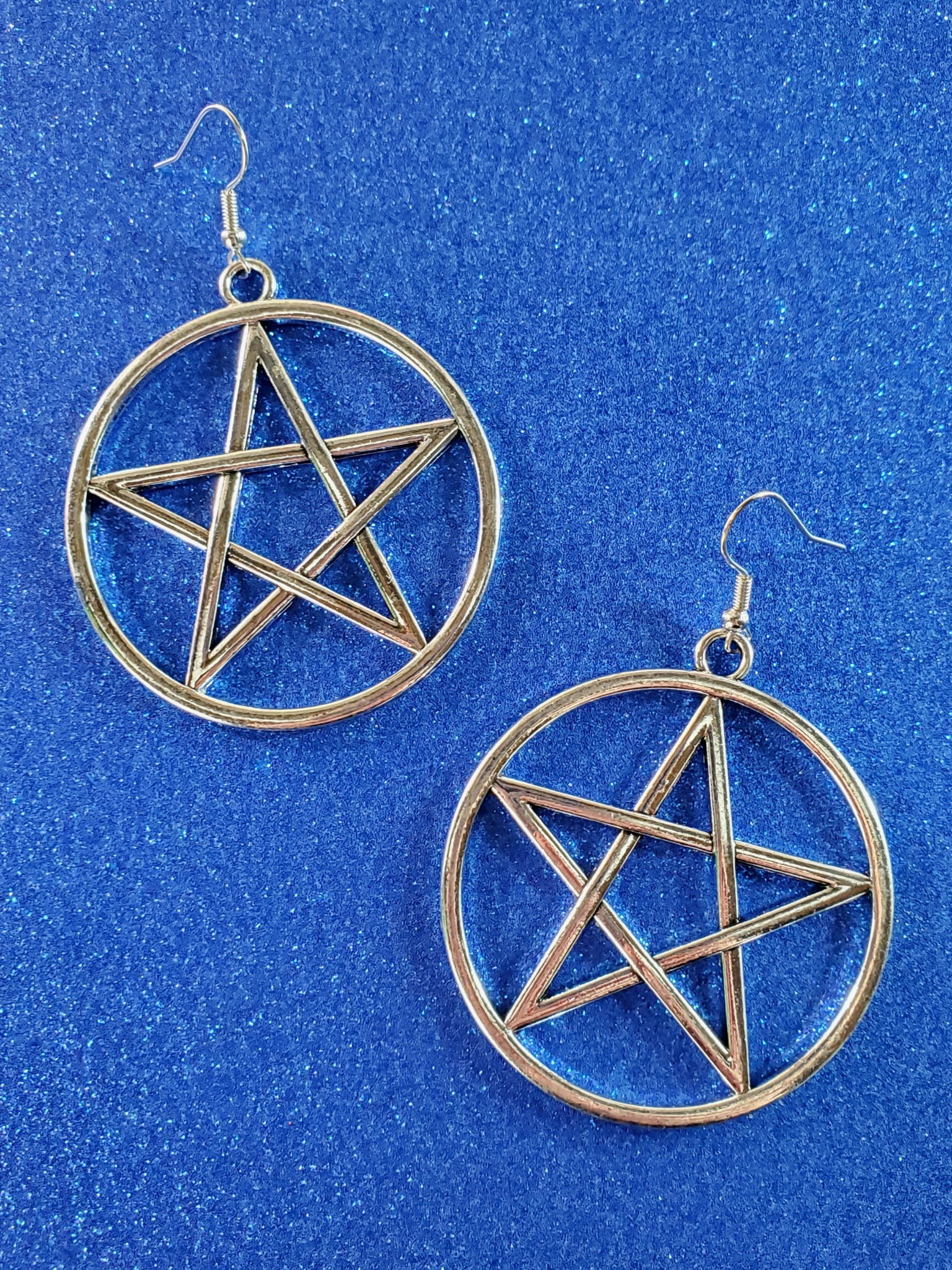 A pair of bold shiny silver metal 2" pentacle dangle earrings with matching metal fishhook style ear wires