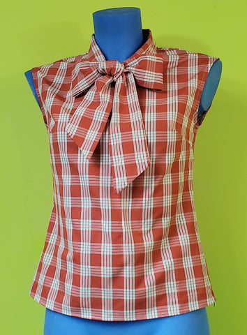 Cotton sleeveless blouse with tie neck detail in a creamy white and red plaid pattern, shown on a mannequin