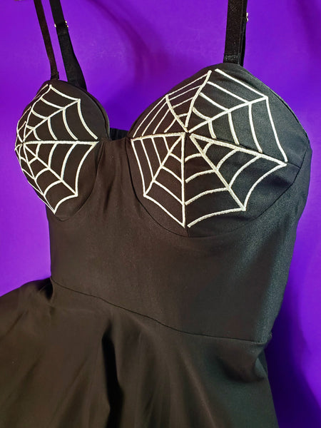 Bodice close up view of black dress with white embroidered spiderweb details on the shaped cups  of the bust