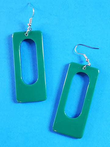 A pair of rectangular acrylic dangle earrings with rounded corners and an oblong hole in the middle. The front of the earring is a rich green color with black on the back 