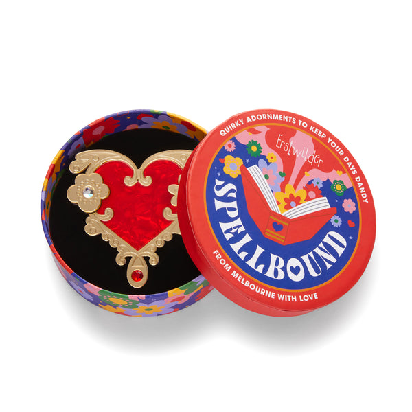 Erstwilder's Spellbound collection "Love or Narcissism" red and gold heart brooch with inset Czech glass crystals, shown in illustrated round box packaging