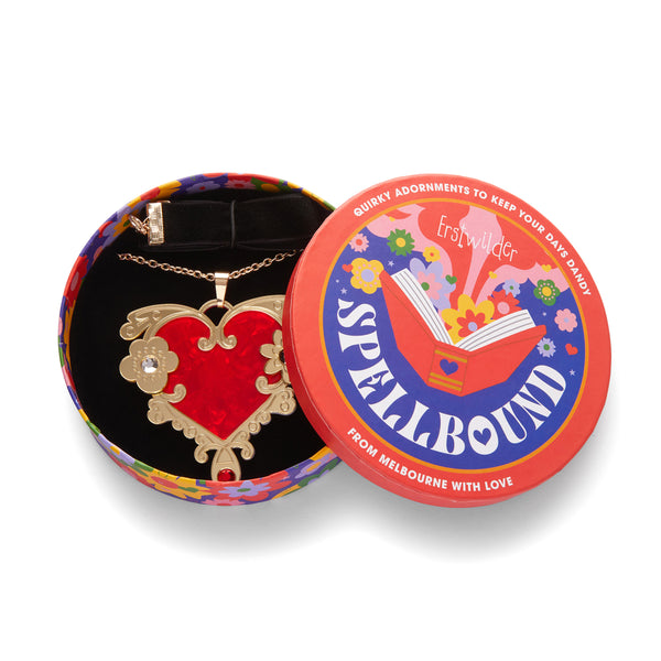 Erstwilder's Spellbound collection "Love or Narcissism" red and gold heart layered resin pendant with inset Czech glass crystals, shown in illustrated round box packaging