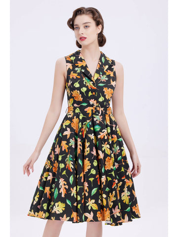 "Autumn Leaves" dark green (almost black) background with allover leaves in oranges and greens print dress sleeveless shirtwaist fitted shawl collar button-front bodice, removable self belt with buckle, flared just below the knee length skirt, shown on model