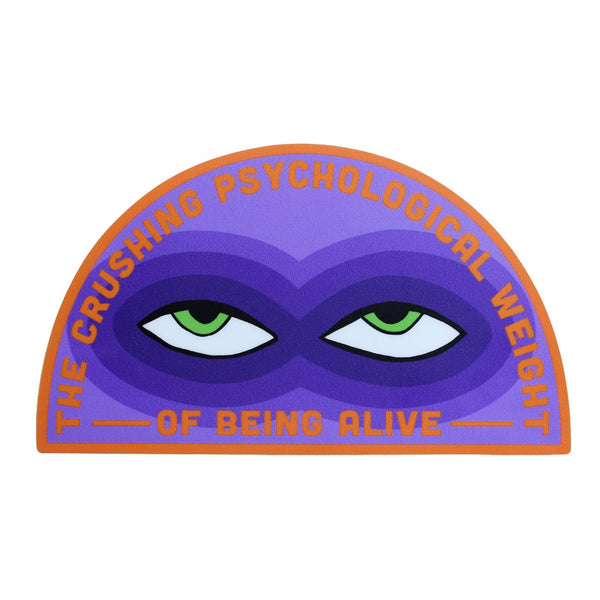 A vinyl sticker with orange borders and writing saying “The Crushing Psychological Weight Of Being Alive”. There is a pair of green eyes surrounded by various shades of purple creating bags under the eyes 