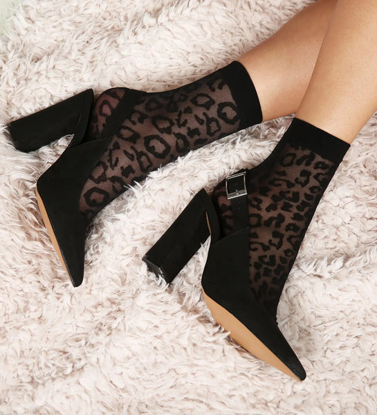 Black mesh ankle socks with a solid black cuff and a leopard pattern. Shown on a model in black heels