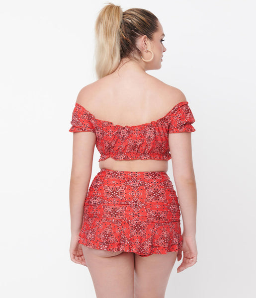 A back view of a model wearing a swim set in a red western bandana print 