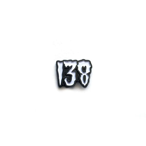 A black and white enamel pin of “138” in classic Misfits drippy horror font