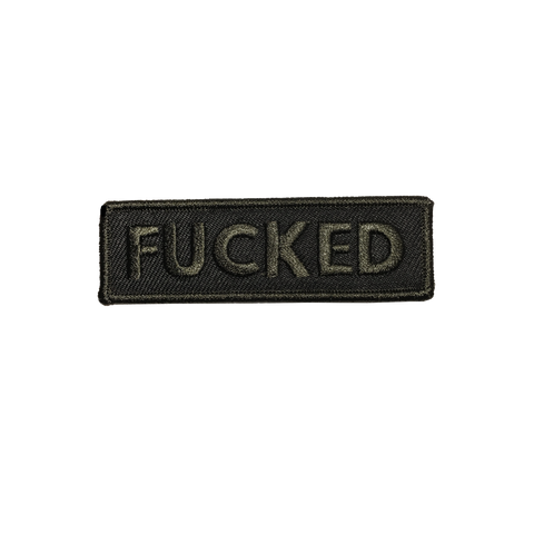 A rectangular embroidered patch with a black background and brownish black border with the word “FUCKED” in capital letters in that same brownish black 
