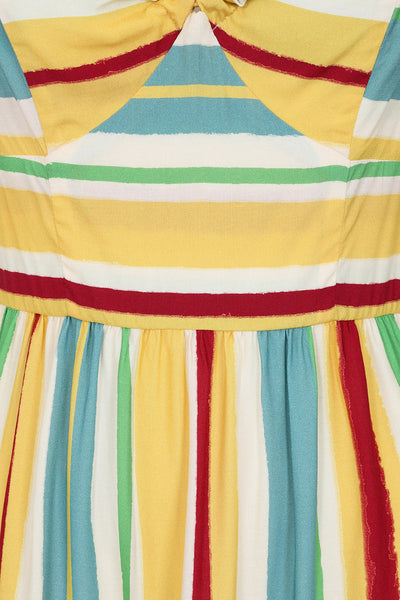 a sleeveless sundress with horizontal red, blue, yellow, white, and seafoam stripes. It has adjustable spaghetti straps, a sweetheart neckline, bamboo ring detail at the bodice, and a three tiered long skirt. Shown zoomed in on bodice detail