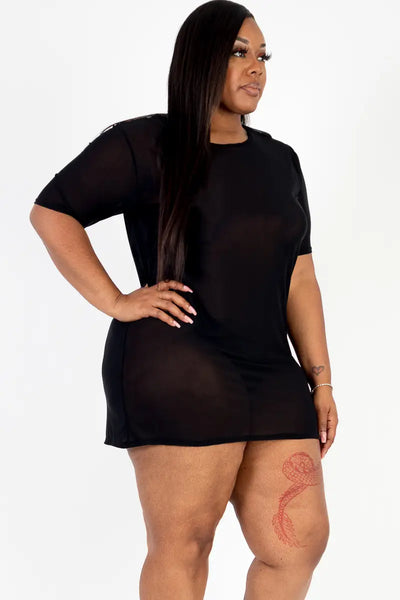 model wearing a short sleeved black mesh mini dress. Shown from a three quarter angle