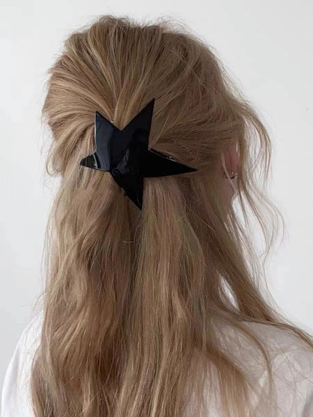 shiny black glitter star shaped barrette with a sturdy pinch clip fastener. Shown on a model 