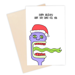 A rectangular greeting card with the message “Happy Holidays! Hope they don’t kill you.” Above an illustration of a purple skinned man with a shaved head wearing a Santa hat opening his mouth to reveal a large green tongue. There are Xs in both of his eyes