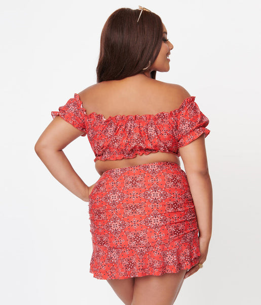 A rear view of a model wearing a red off the shoulder swim top and bottom in a red western bandana print
