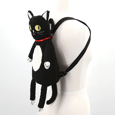A backpack in the shape of a plush cat with dangling arms and legs & black shoulder straps shown on a mannequin 