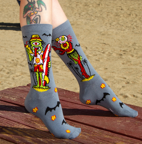 pair grey background monsters dressed for beach holiday crew length socks, shown on model