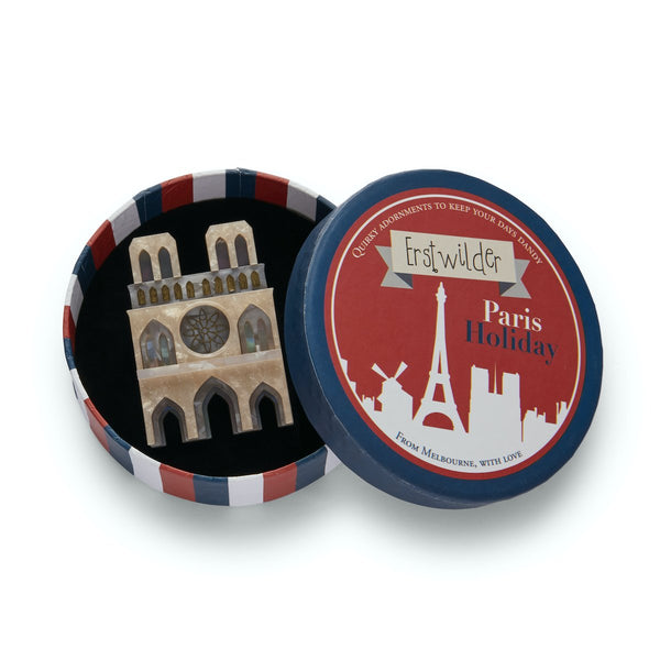 Paris Holiday Collection "Our Lady of Paris" layered resin Notre Dame Cathdral brooch, shown in illustrated round box packaging