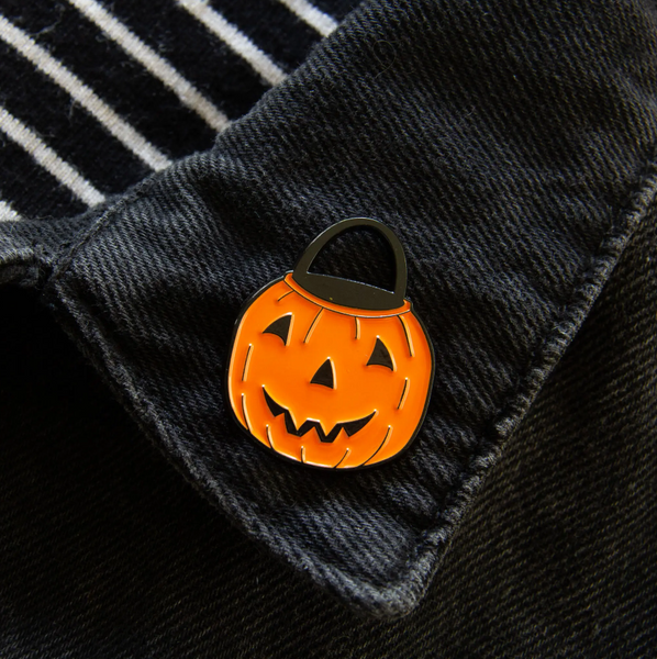 Vintage style orange jack-o'-lantern Halloween treat bucket enameled black metal clutch back fastener pin, shown on denim jacket