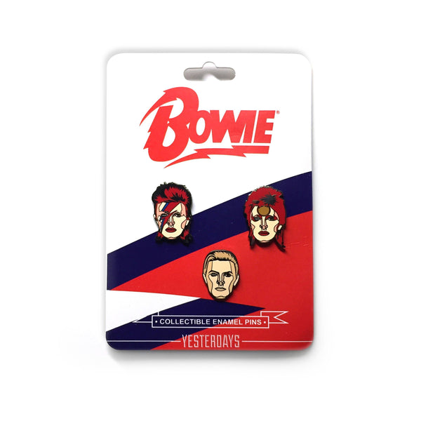 set of three David Bowie portrait enameled metal pins, each depicting a different era persona, shown on illustrated cardstock backer packaging